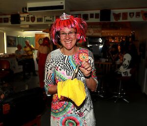 Lady wearing a pink wig holding a present