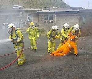 Macca fire team rescue a simulated casualty during a fire training drill.