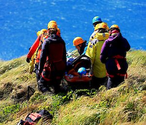 The stretcher being carried by the search and rescue team back down the slope.