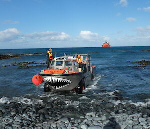 A LARC (Light Amphibious Resupply Cargo vessel) coming ashore at Landing Beach, Macquarie Island, with the RV Aurora Australis in the background during sunny and calm conditions