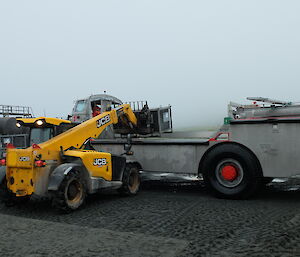 A JCB Telehandler loading a cage pallet of recycling onto the deck of one of the AAD LARCs ready to Return to Australia for processing