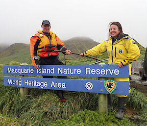 Outgoing Ranger In Charge Andrea Turbett hands a wooden staff to Incoming Ranger In Charge Chris Howard