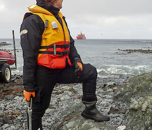 Danielle McCarthy holding an anchor and looking out towards the AA in the distance