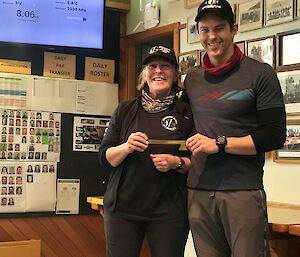 Outgoing Station Leader Kyle Willliams hands a large brass key to incoming Station Leader Ali Dean during a handover ceremony on Macquarie Island