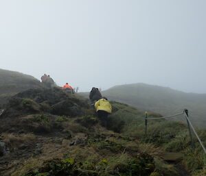 Expeditioners heading up Wireless Hill in the fog to the Tsunami cache during a response drill