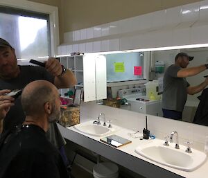 Tim Kerr cutting Norbert Trupps hair in the Hass House bathroom at Macca