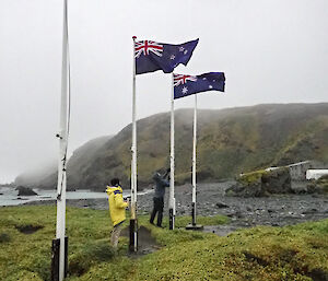 Two expeditioners raise the flags from halfmast to mast head during the Anzac Day service held at Macquarie Island this week