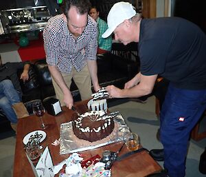 Jeremy Bird cutting his birthday cake and Peter Lecompte helping to serve