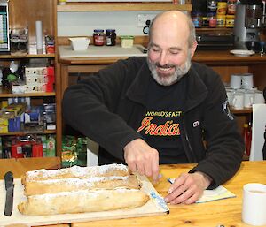 Norbert Trupp sitting in the mess at Macca about to cut up his birthday triple strudel