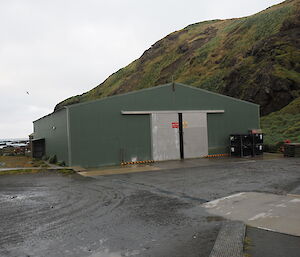 A view of the station storage facility, the Green Store with Wireless Hill behind, Macquarie Island