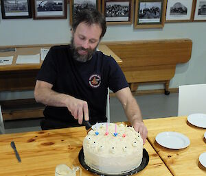 Greg Sandrey cutting into his birthday cake in the mess at Macca