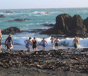 Expeditioners at Macca heading into the surf for the Midwinter swim