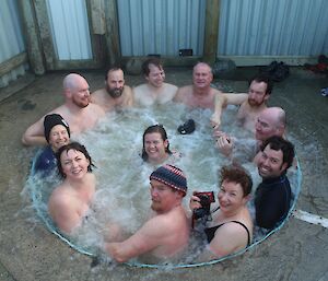 The twelve expeditioners that took part in the Midwinter swim warming themselves in the Macca al fresco spa