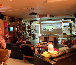 Soiree attendees watch tennis highlights on the big screen at Macca