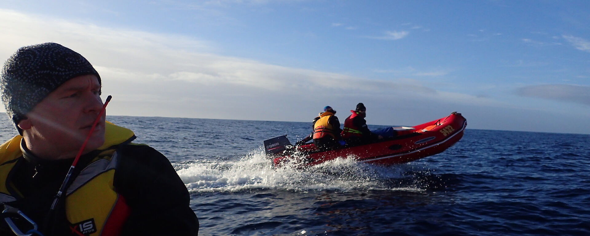 A view from one IRB on the water to another while heading south to Waterfall Bay on Macquarie Island. Rchard Youd is visible in one boat and Greg, Jez and Danielle are visible in the other.