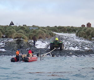 Chris H and Ali in the IRB come onto the trailer backed into the surf by Chris B on the tractor with Tim as lookout