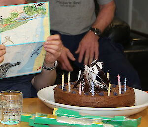 Vicki Heinrich reads her birthday card with her birthday cake on the table in front of her ready for serving