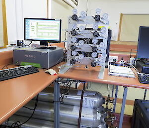 PICARRO air sampler setup. Showing the calibration gas cylinders under the bench and the cylinder regulators next to the computer — the computer screen showing the real-time atmospheric monitoring by the PICARRO analyser. Showing carbon dioxide at 402 ppm, methane 1.8 ppm