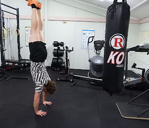 Man doing a handstand in the gym