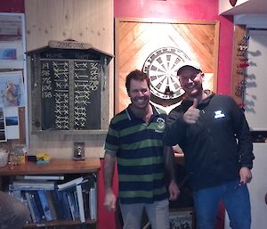 Chris B & Rich in front of a dartboard in Macca Mess