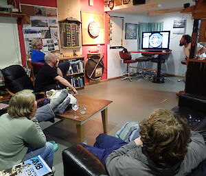 The Macca audience watching the screen as Davis throws in the recent inter-station darts match