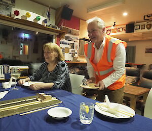 Peter turning the mechanism that pulls the sushi train along tracks running the length of the table.