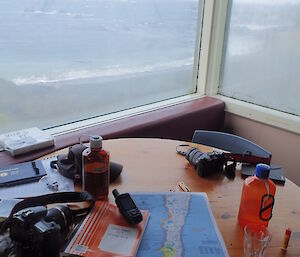 A table full of maps and field equipment at Hurd Point hut