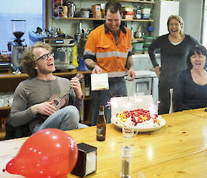 Fellow expeditioners help Angus to celebrate his birthday