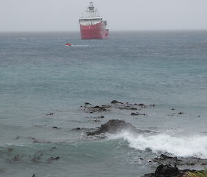 The red RIB returning to the ship for another load of cargo