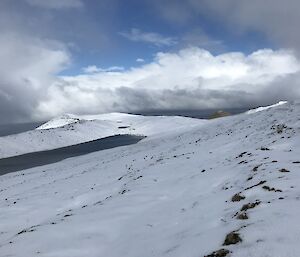 Blue sky and sunshine breaking through on a grey and white landscape — a view on the Varne Plateau after a rare snowfall