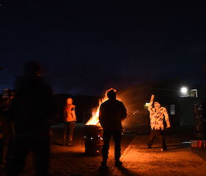 Gathering of expeditioners around a bonfire in a drum for Guy Fawkes night