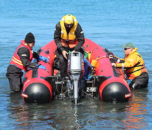 Annie and Chris launch the boat into deeper water as Luke starts the outboard