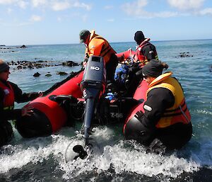 Stu and Angus steady the boat as Chris starts the motor and Cathryn keeps an eye out for kelp