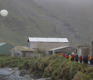 Tourists on Macquarie Island watch a balloon release during their visit to the island on board the Professor Khromov / Spirit of Enderby