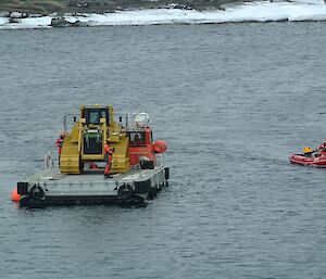 Dozer on the barge being transported to shore