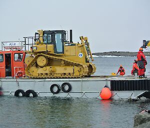 Dozer at the shore on the barge