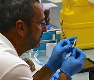 The station chef is carefully clearing bubbles from the syringe.