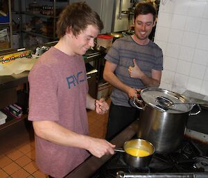 Dale and Angus demonstrating how to cook to the the others in the kitchen