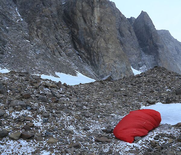 A red bivy bag on the rocks will keep you alive in bad weather