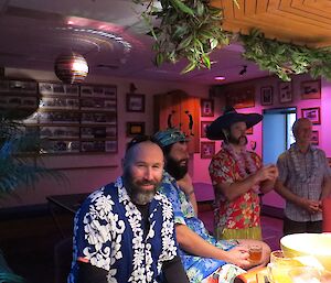 Expeditioners dressed in hawaiian shirts gather for a theme party