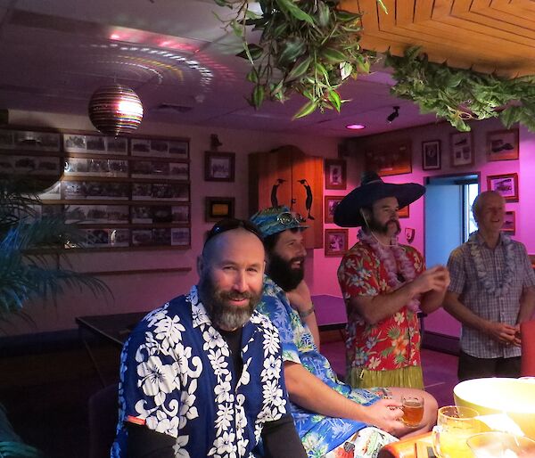 Expeditioners dressed in hawaiian shirts gather for a theme party