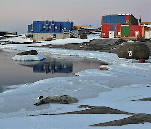 Chippies workshop and power house in the late afternoon sunlight, seal in foreground sleeping