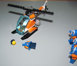 Lego men being briefed on the safe way to approach a helicopter