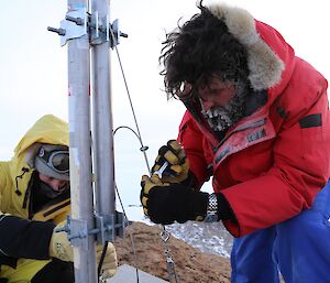 The technicians Angus and trevor are attaching wires to the antenna to secure it in high winds