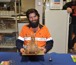 Bearded male expeditioner in safety clothing with his kangaroo birtday cake