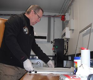 John prepares a sheet to collect airborne particles