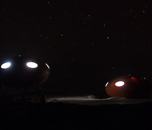 Spaceship shaped huts at night with oval windows
