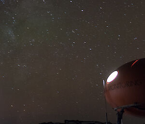 The night sky at Mawson is littered with stars, taken from below an oval hut