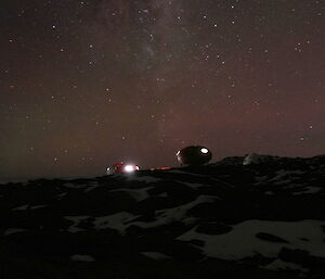 Night sky has a flame-like tinge. Many stars can be seen with spaceship-like huts on the horizon