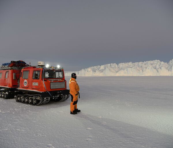 Paul standing on the sea ice next to the hagglunds looking off in the distance